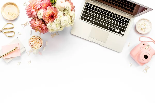 Tarz sahibi kadınların ofis masası. Laptop, bilgisayar, buket ranunculus ve güllerle çalışma alanı, beyaz arka planda pano. Düz yatıyordu. Üst görünüm.