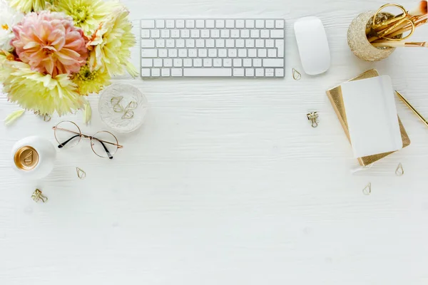 Escritorio de oficina de mujeres laicas planas. Espacio de trabajo femenino con ordenador, rosas rosadas y amarillas flores, accesorios, diario, gafas sobre fondo blanco. Vista superior —  Fotos de Stock