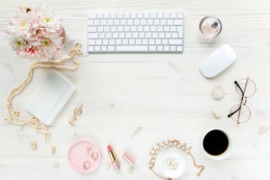 Üst kat ofis masası. Çalışma alanı, bilgisayar, kasımpatı, pano. Beyaz ahşap arka planda izole kadın aksesuarları. Düz yatıyordu