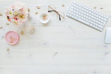 Üst kat ofis masası. Çalışma alanı, bilgisayar, kasımpatı, pano. Beyaz ahşap arka planda izole kadın aksesuarları. Düz yatıyordu