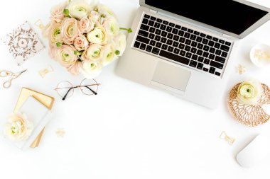 Tarz sahibi kadınların ofis masası. Laptop, bilgisayar, buket ranunculus ve güllerle çalışma alanı, beyaz arka planda pano. Düz yatıyordu. Üst görünüm.