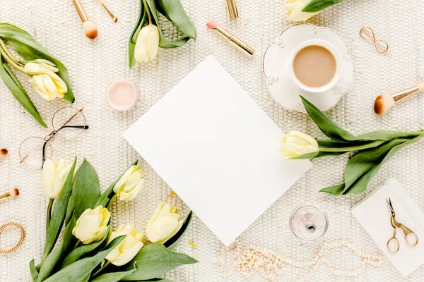 Sarı lale çiçekli kadın çalışma alanı, kadınların moda altın aksesuarları, günlük, beyaz arka planda gözlük. Düz yatıyordu. Üst görünüm kadınsı.