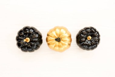 Şık Cadılar Bayramı süslemeleri. Dekoratif balkabağı siyah ve altın cadılar bayramı beyaz arka planda izole. Düz yatış, üst görünüm.