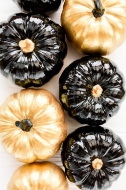 Şık Cadılar Bayramı süslemeleri. Dekoratif balkabağı siyah ve altın cadılar bayramı beyaz arka planda izole. Düz yatış, üst görünüm.