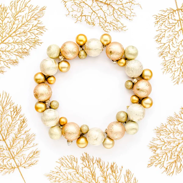 Holiday round frame, pattern made and gold glass Christmas balls, golden leaves isolated on a white background. Merry Christmas. Flat lay, top view