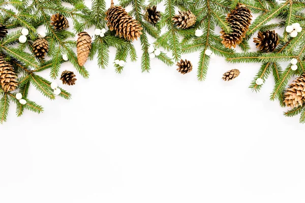 Composição de Natal com ramos de abeto, cones de pinheiro em fundo branco. Deitado plano, vista superior — Fotografia de Stock