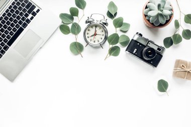 Ofis masası. Bilgisayar, bilgisayar, kamera, sulu. Düz kompozisyon, dergiler, sosyal medya ve sanatçılar. Üst görünüm, ev ofis çalışma alanı