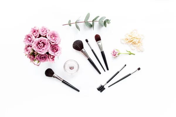 Makeup tools. Home office workspace. Female fashion, makeup brushes, cup of coffee on white background. Flat composition. Top view. Flat lay.