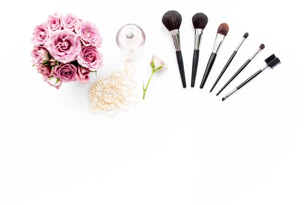Makeup tools. Home office workspace. Female fashion, makeup brushes, cup of coffee on white background. Flat composition. Top view. Flat lay.