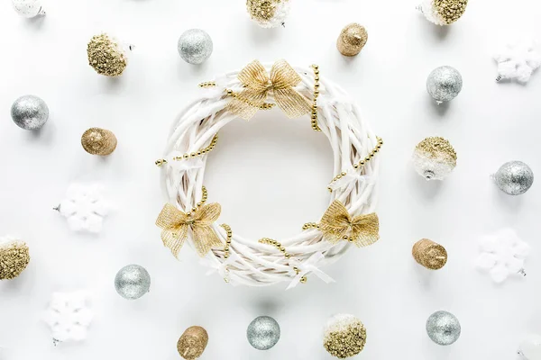 Świąteczna rama wieńcowa wykonana z kolorowych złotych kulek świątecznych na białym tle. układanie płaskie, widok z góry — Zdjęcie stockowe