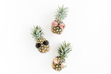 Beyaz arka planda gözlüklü hippi ananasları. Düz yatış, üst görünüm