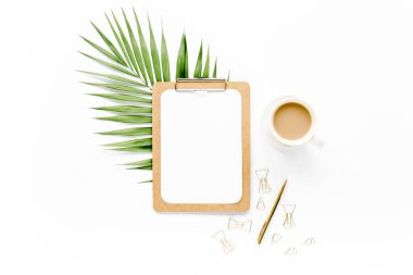 Pano, palmiye yaprağı, bir fincan kahve ve klipsli maket. Düz yatış, üst görünüm