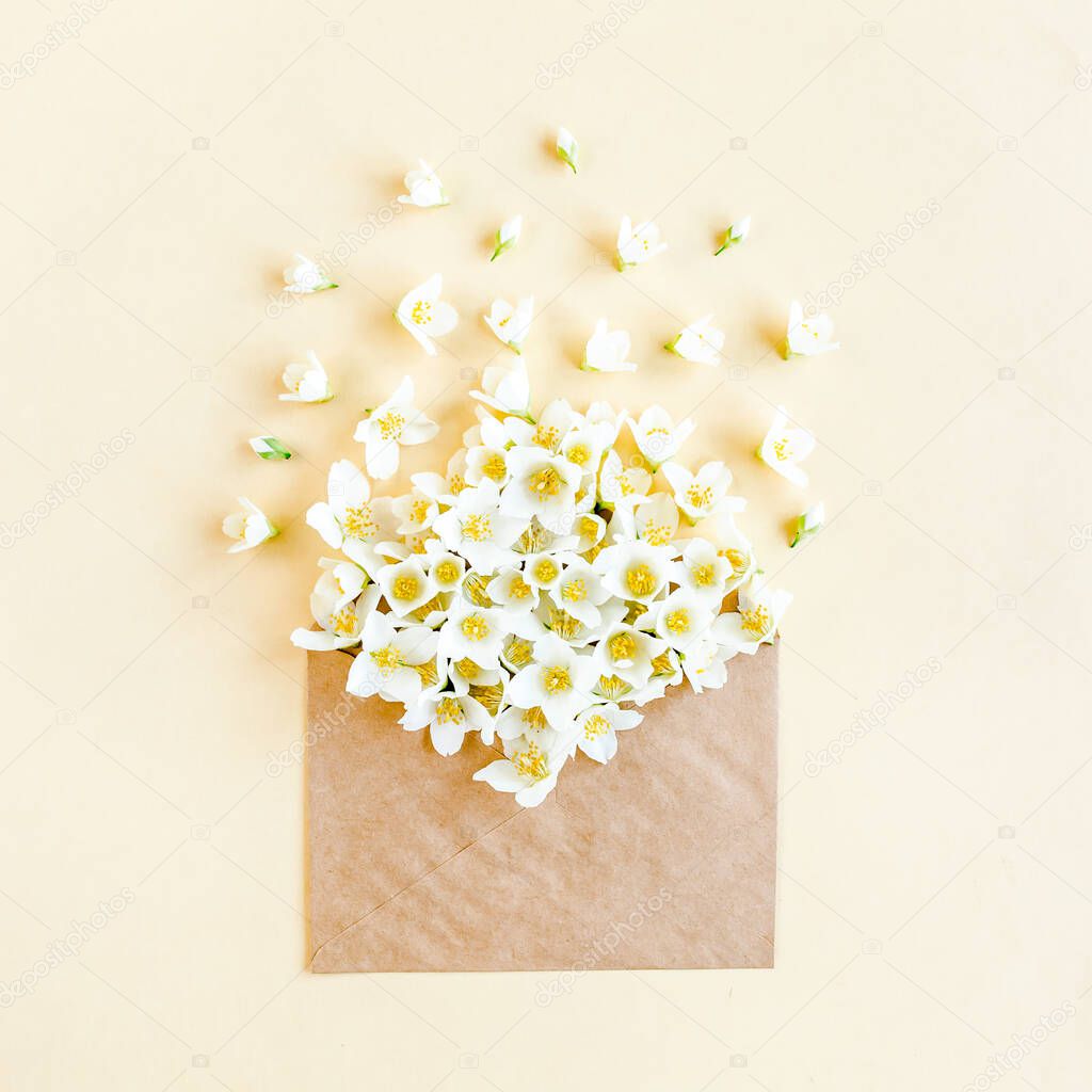 Creative layout of their Jasmine bouquet in a crab envelope on a beige background. lay flat, top view