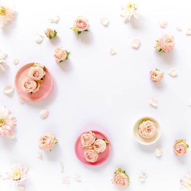 Pembe güllerden, yeşil yapraklardan, beyaz arkaplanda dallardan oluşan çiçek deseni. Düz yerde, üst tarafta. Sevgililer Günü geçmişi. Çiçek deseni. Desen 