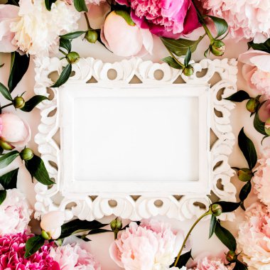Beyaz arka planda güzel pembe şakayıklardan oyulmuş beyaz bir çerçeve. Düz yerde, üst tarafta. Sevgililer Günü geçmişi. Çiçek çerçevesi. Şakayık dokusu.