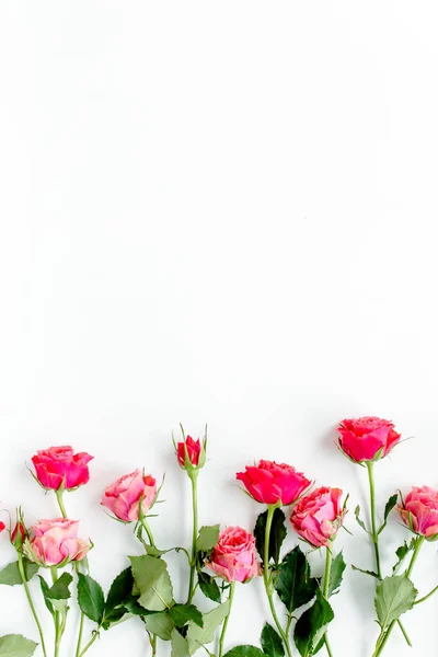 Moldura de borda de flor feita de rosas vermelhas no fundo branco com espaço de cópia para texto. O passado dos namorados. Padrão floral. Deitado plano, vista superior. — Fotografia de Stock