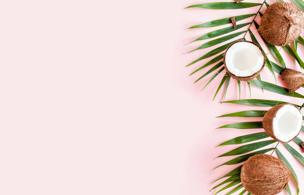 Pattern, frame borders with coconuts and tropical palm leaves on pink background. Tropical abstract background. Flat lay, top view.