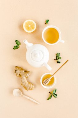 Nane, zencefil, limon, bal ve sarı arka planda diğer otlarla birlikte bitki çayı. Düz yatış, üst görünüm.