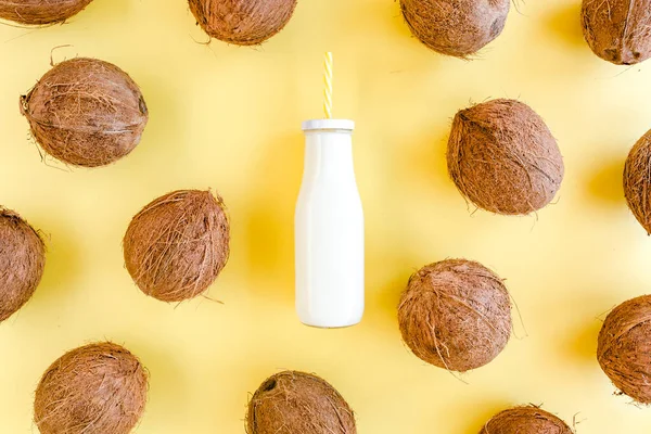 Mönster, konsistens med kokosnötter och kokosmjölk, cocktail på gul bakgrund. Tropisk abstrakt bakgrund. Platt ligg, ovanifrån. — Stockfoto