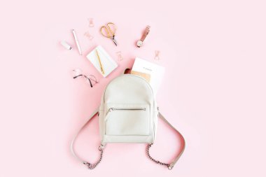 Pembe arka plan manzaralı kadın bej sırt çantası ve moda aksesuarları. Düz bir kadınsı görünüş. Üst görünüm.