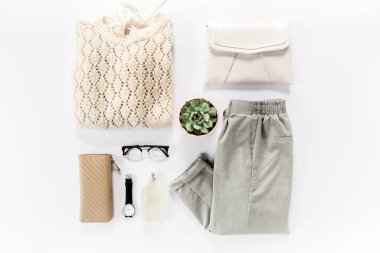 Kadın kıyafetleri ve aksesuarları beyaz arka planda. Modern ve gündelik kıyafetler. Moda, alışveriş ve makyaj konsepti. Düz yatış, üst görünüm. 