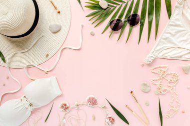 Gezgin aksesuarları, kadınlar yaz bikini takımı, pembe arka planda tropikal palmiye yaprağı dalları. Seyahat tatili konsepti. Düz yatış, üst görünüm. 