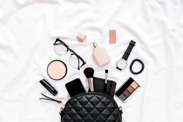 Womens fashion. Black handbag, makeup brushes, cosmetics, sunglasses, accessories on white background. social media. Top view. Flat lay. — Stock Photo, Image