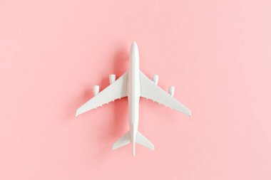 Beyaz model uçak, pembe arka planda uçak. Üst manzara, düz yatış. Pankart.