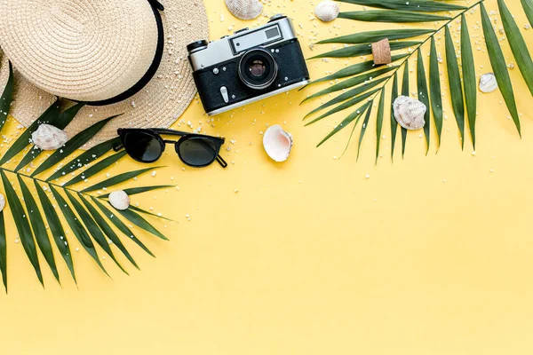 Accesorios para viajeros, ramas de hojas de palma tropicales sobre fondo amarillo con espacio vacío para texto. Fondo de verano. Piso tendido, vista superior. — Foto de Stock