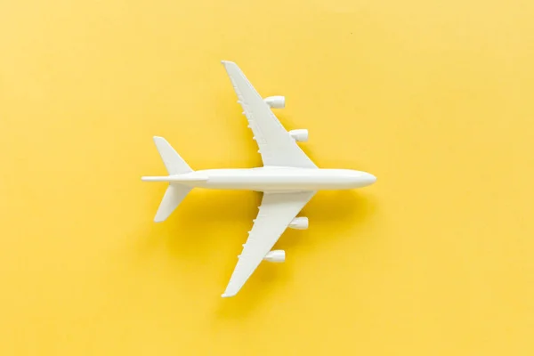 Avión modelo blanco, avión sobre fondo amarillo. Vista superior, plano. —  Fotos de Stock