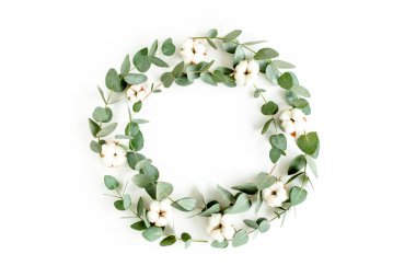 Okaliptüs dallarından, yapraklardan ve beyaz arka planda izole edilmiş pamuktan yapılmış çelenk çerçevesi. düz yatış, üst görünüm