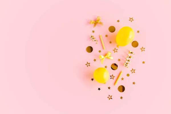 Gold confetti, balloons, streamers on a pink background. Colorful celebration, birthday. Christmas or New Year pattern. Flat lay, top view