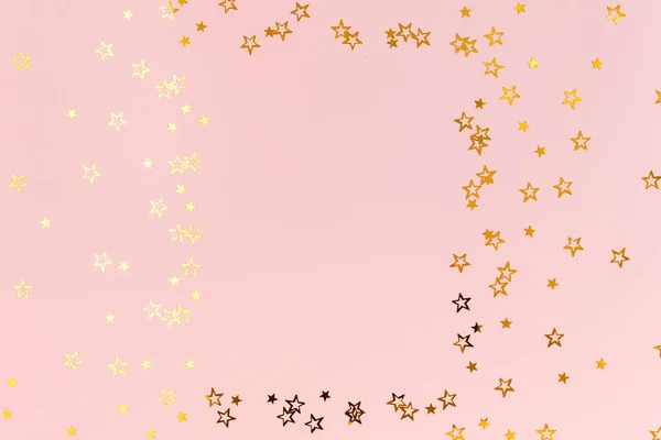 Marco de fotos maqueta con espacio para el texto, confeti dorado sobre un fondo rosa. Una celebración colorida. Patrón de Navidad o Año Nuevo. Piso tendido, vista superior — Foto de Stock