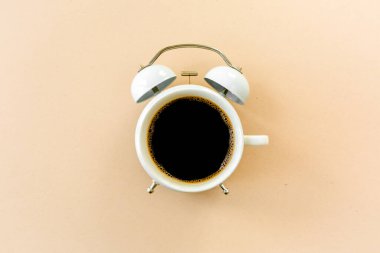 Kahve zamanı, sarı arka planda saat. Düz yatış, üst görünüm