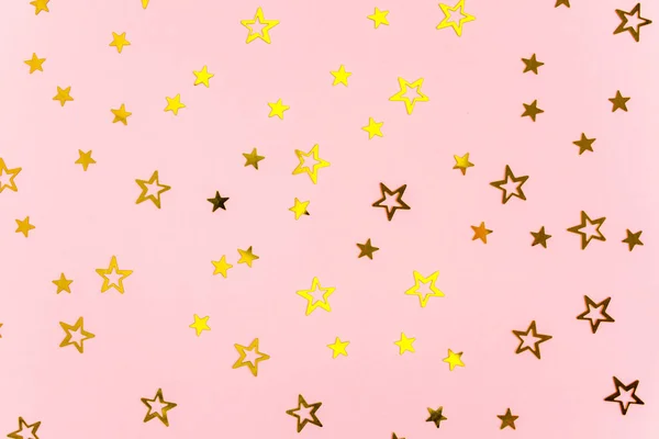 Золотые звезды Конфетти на розовом фоне. Праздничный фон. Красочный праздник, день рождения. Рождество или Новый год. Плоский, вид сверху — стоковое фото