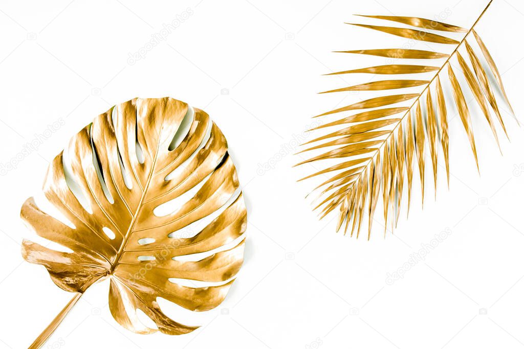Gold tropical palm leaves Monstera on white background. Flat lay, top view minimal concept.