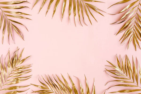 Hojas de palma tropical dorada sobre fondo rosa. Plano laico, vista superior concepto mínimo. — Foto de Stock