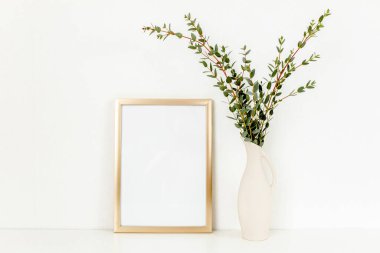 Boş çerçeve modeli ve okaliptüs dalları açık arkaplanda, vazoda. Ev dekoru. Günlük, web sitesi veya sosyal medya kavramı.