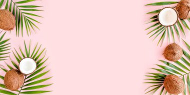 Kalıp, çerçeve kenarları, hindistan cevizi ve pembe arka planda tropik palmiye yaprakları. Tropik soyut arka plan. Düz yatış, üst görünüm.