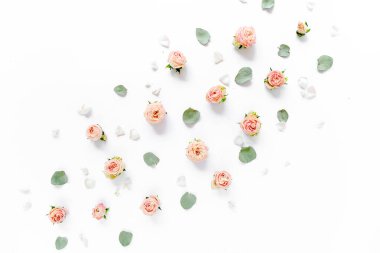 Pembe güllerden, yeşil yapraklardan, beyaz arkaplanda dallardan oluşan çiçek deseni. Düz yerde, üst tarafta. Sevgililer Günü geçmişi. Çiçek deseni. Desen 