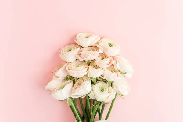 Mazzo di fiori ranuncoli rosa pastello su sfondo rosa. Concetto floreale minimo. Posa piatta, vista dall'alto. — Foto Stock