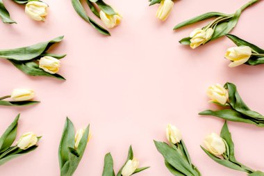 Pastel ve sarı lale çiçeği demeti pembe arka planda. Düz yerde, üst tarafta. Sevgililer Günü geçmişi. Çiçek deseni.