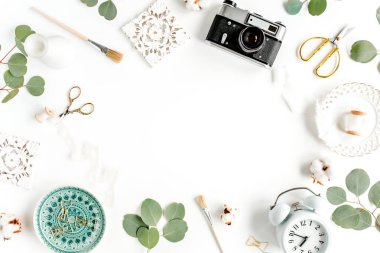 Seramik yaprak canavarlı çalışma alanı, retro kamera, okaliptüs yaprağı, beyaz arka planda aksesuarlar. Düz konum. Üst görünüm