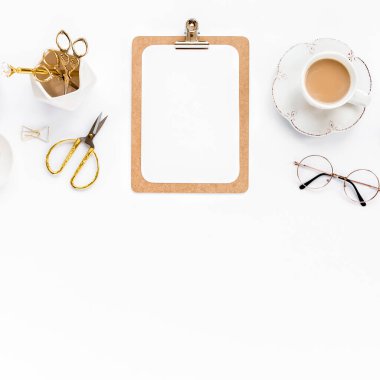 Beyaz arka planda panosu, not defteri ve altın aksesuarları olan ofis çalışma alanı. Düz yatış, üst görünüm