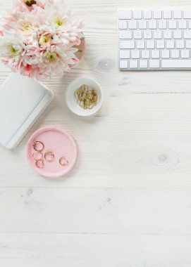 Üst kat ofis masası. Çalışma alanı, bilgisayar, kasımpatı, pano. Beyaz ahşap arka planda izole kadın aksesuarları. Düz yatıyordu