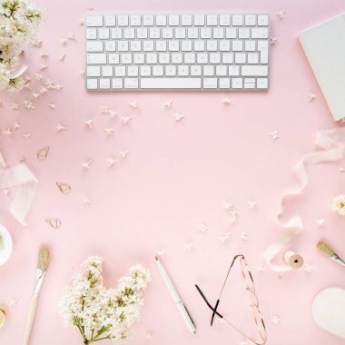 Ofis masasında bilgisayar, leylak ve dosya var. Dergiler. Üst Manzara Düz Yatıyordu. Merkez ofis çalışma alanı. Pembe arka planda kadın moda aksesuarları