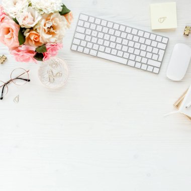 Düz uzanmış kadınların ofis masası. Bilgisayarlı kadın çalışma alanı, pembe güller çiçekler, aksesuarlar, altın günlük, beyaz arka planda gözlük. Üst görünüm 