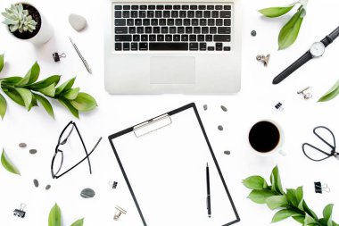 Ofis masası Kağıt boş, yeşil yapraklı çalışma alanı çerçevesi. Dizüstü bilgisayar, beyaz arka planda gözlük. Dergiler, web siteleri, medya. Düz yatış, üst görünüm