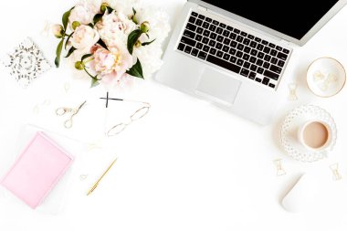 Düz uzanmış kadınların ofis masası. Dizüstü bilgisayarı olan bir kadın çalışma alanı, pembe şakayık buketi, beyaz arka planda aksesuarlar. Üst görünüm kadınsı arkaplan.