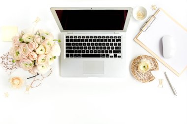 Tarz sahibi kadınların ofis masası. Laptop, bilgisayar, buket ranunculus ve güllerle çalışma alanı, beyaz arka planda pano. Düz yatıyordu. Üst görünüm.